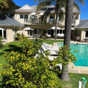 Constantia Valley Lodge: a house with a swimming pool and a palm tree