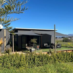 Croxley Farm: a small black house with a patio and lawn