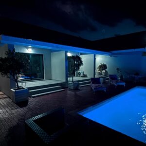Dar Al Noor - Aviation Residence: a house with a swimming pool at night