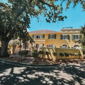 De Haas Luxury Living at Villa Grande: a yellow house with a fence in front of it