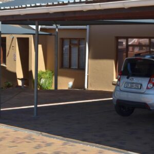 De Helling Self Catering: a car parked in a parking lot in front of a house