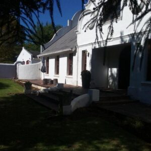 De Plaashuis: a white house with a porch and a yard