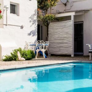 Die Opstal house with Apartments: a small blue swimming pool in front of a house