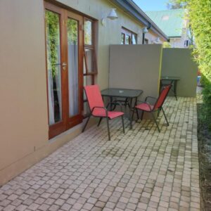 Dilisca Guesthouse: a patio with a table and chairs on a patio