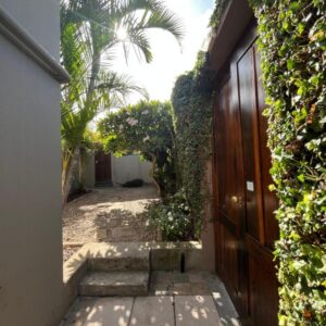 Dolphin Circle Bed and Breakfast: a hallway of a house with a gate and a palm tree