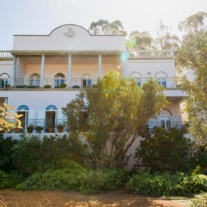 Dorp Hotel: a large white building with trees in front of it