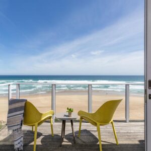 Dune Beach House: two chairs and a table on a balcony overlooking the beach