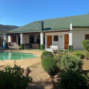 Emma's Place: a house with a swimming pool in front of it