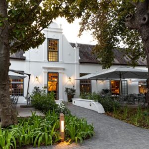 Erinvale Estate Hotel & Spa: a white building with tables and chairs and trees