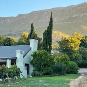 Esperon: a white house with trees and mountains in the background