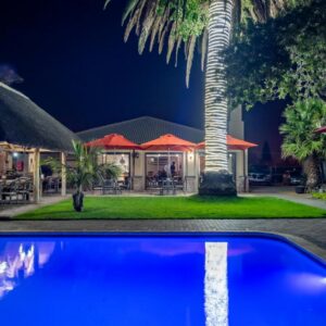 Excellent Guest House: a house with a palm tree and a swimming pool
