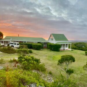 Fairhill Nature Reserve and Guest House: a house with two vans parked in a field