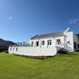 Firgrove Country Lodge: a white building with a grass field next to it