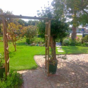 Fisherhaven Guest House: a garden with a wooden pergola and some plants