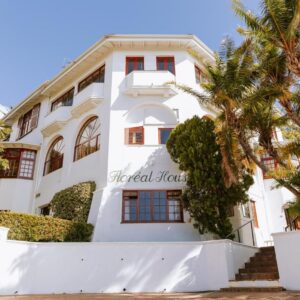 Floreal House: a white building with palm trees in front of it
