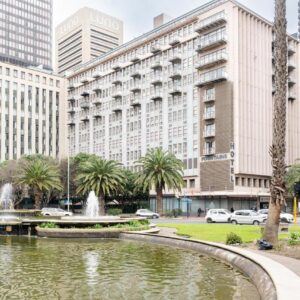 Fountains Hotel by Neighbourgood: a fountain in the middle of a city with tall buildings