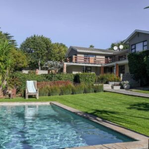 Four Palms Accommodation: a backyard with a swimming pool and a house