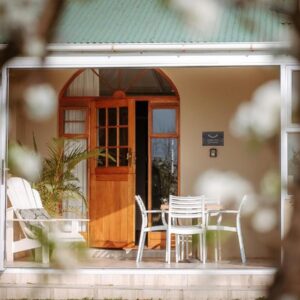 Franschhoek Farm Cottages: a table and chairs on the porch of a house