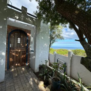 Garden Route Self-Catering: a door to a house with a view of the ocean