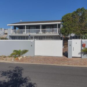 Gardenia Guesthouse: a house with white doors and a fence