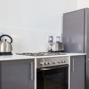 Gardens Centre Holiday Apartments: a kitchen with a stove and a refrigerator