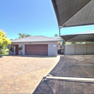 Glennies Guesthouse: a house with a brick driveway in front of a garage