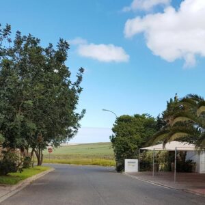 Golden Key Guesthouse: a street with trees and a building and a blue sky
