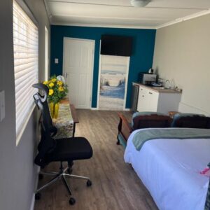 Grace from Above: a bedroom with a bed and a desk and a chair