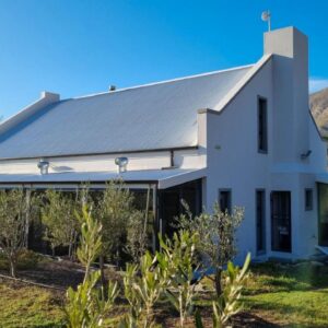 Great Heart Farm: a white house with a silver roof on a hill