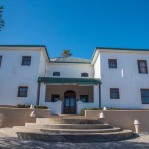 Grootvlei Guest Farm: a large white building with stairs in front of it