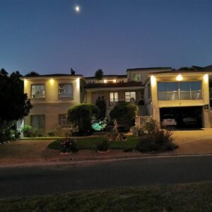 Guinea Fowl Self Catering: a large house at night with the moon in the sky