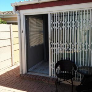 Hamilton Garden Suites: a screened in porch with two chairs and a table