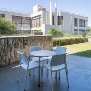 Harbour House Hotel - Le Paradis Apartments: a patio with a table and chairs and a building