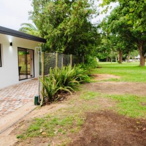 Heather Road Cottages: a house with a fence and a yard
