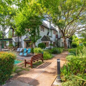 Hedge House Guest House: a house with a bench in the garden