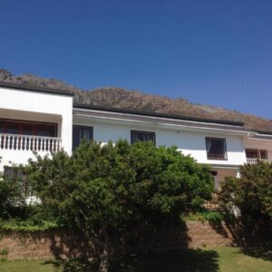 Helderberg Guesthouse: a white house with a mountain in the background