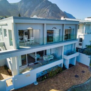 Hermanus Beachfront Lodge: an aerial view of a house with mountains in the background