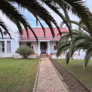 Herold Meander Country House: a white house with a red roof and a palm tree