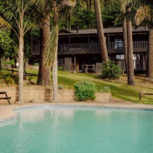 Highlands Lodge Mountain Retreat: a swimming pool in front of a house with palm trees
