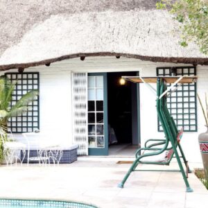 House of Perez: a house with a thatch roof and a chair outside