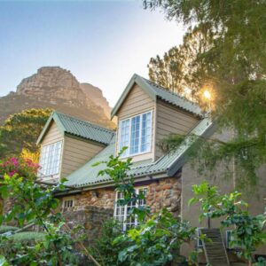 Houtkapperspoort Mountain Cottages: a stone house with a mountain in the background