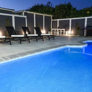 Howards Villas: a swimming pool with chairs and a picnic table next to it