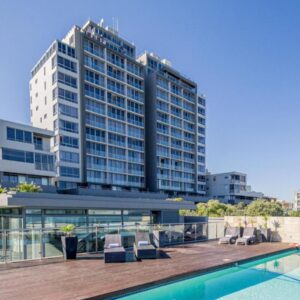 Infinity Self Catering Apartments: a hotel with a swimming pool and a building