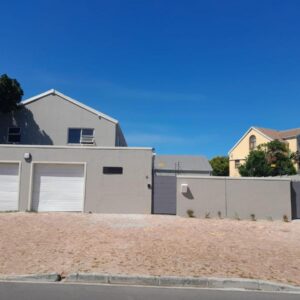 Inkantu Apartments & Suites: a house with two garage doors and a fence