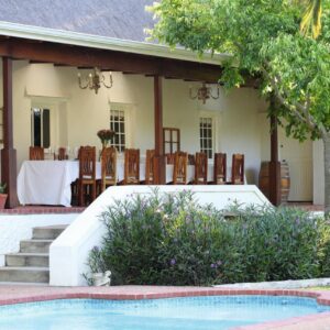 Joubertsdal Country Estate: a house with a pool and a table and chairs