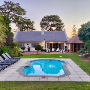 KaapsePracht Bed & Breakfast: a house with a swimming pool and chairs in the yard