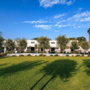 Karoo Retreat- Self Catering Villas and Guest House: a large yard with a building and a palm tree