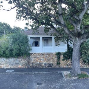 Kloof Nest Guest House: a house with a tree in front of a brick wall