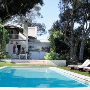 Kloofzicht Estate Country House: a swimming pool in front of a house with chairs