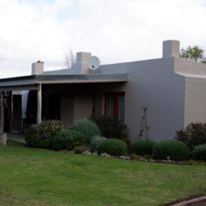 Kuruma Farm Cottages: a small white house with a yard